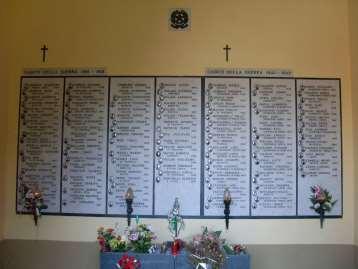 Ai Caduti delle due guerre mondiali Trattasi di sette lastre in marmo bianco sulle quali compaiono le fotografie, i nominativi e le generalità dei
