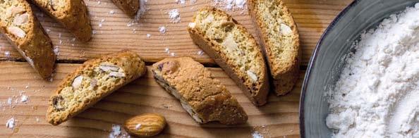 I filoncini di impasto alle mandorle, infatti, vengono cotti interi in forno e poi tagliati e boscottati, per diventare cantucci croccanti e dorati.